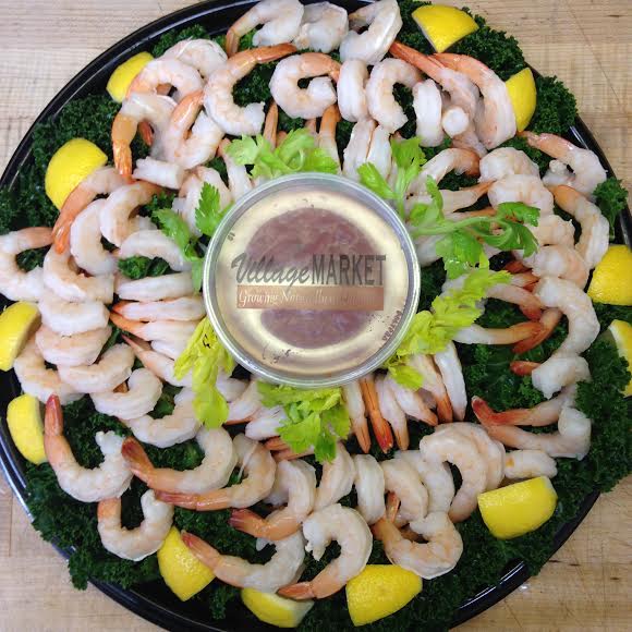 Top down view of a shrimp cocktail platter with lemons and cocktail sauce